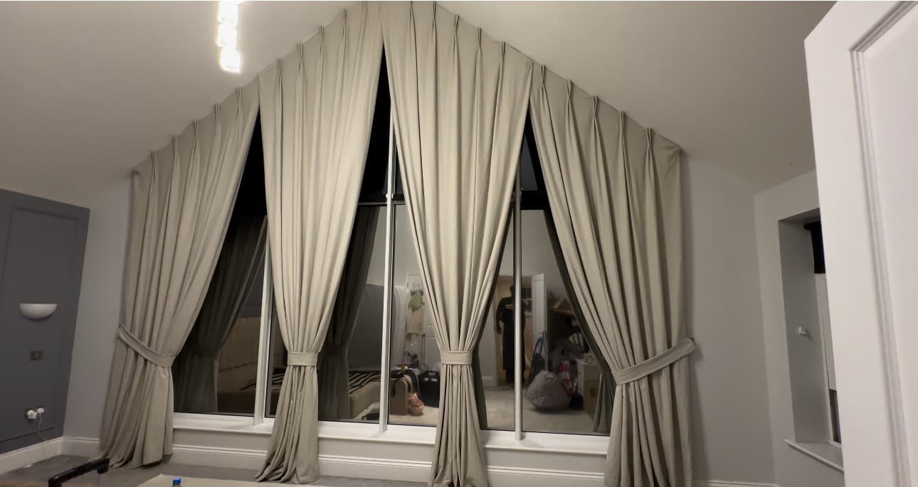 Made-to-measure curtains fitted to a large apex window